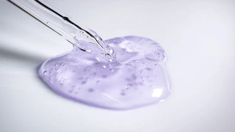 Lahvička s lubrikačním gelem a kapka průhledného gelu