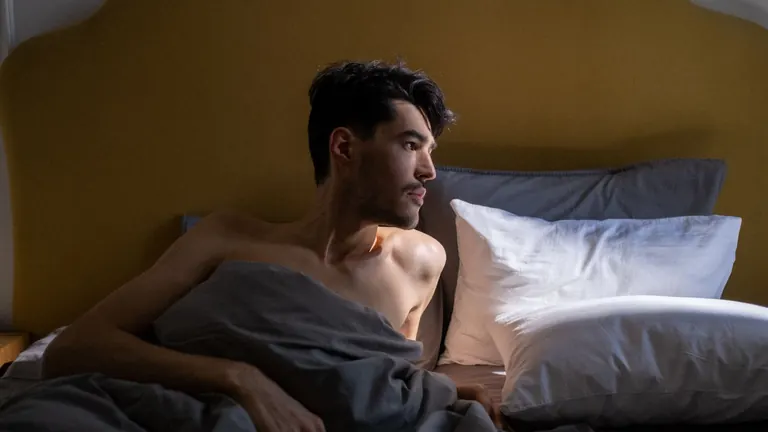 Uvolněný muž na posteli před první masáží prostaty